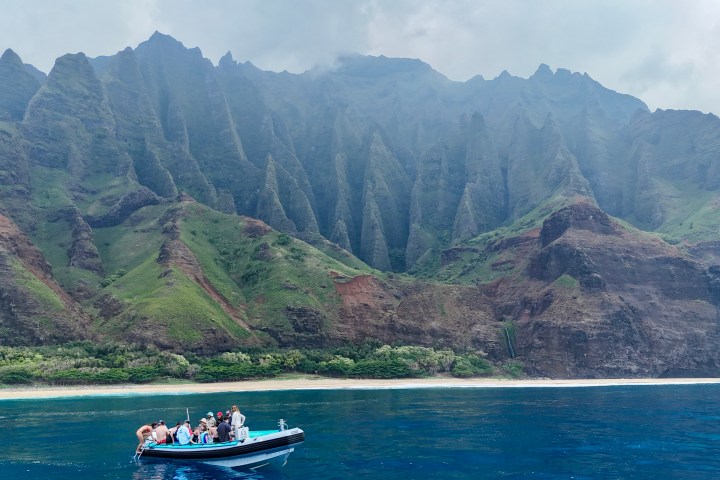 a small boat in a body of water with a mountain in the background