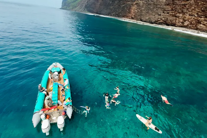 a group of people standing next to a body of water