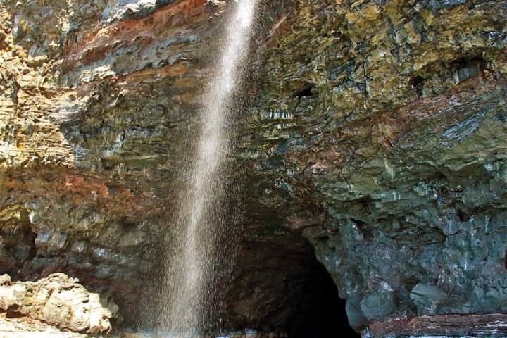 Pirates Sea Cave with a waterfall in front of the entrance on the Na Pali Coast
