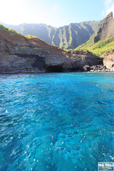 a large body of water with a mountain in the background