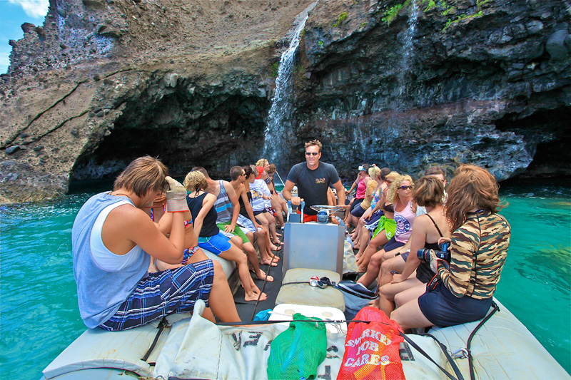 A Na Pali Coast Raft Tour in Front of a Sea Cave and a Waterfall
