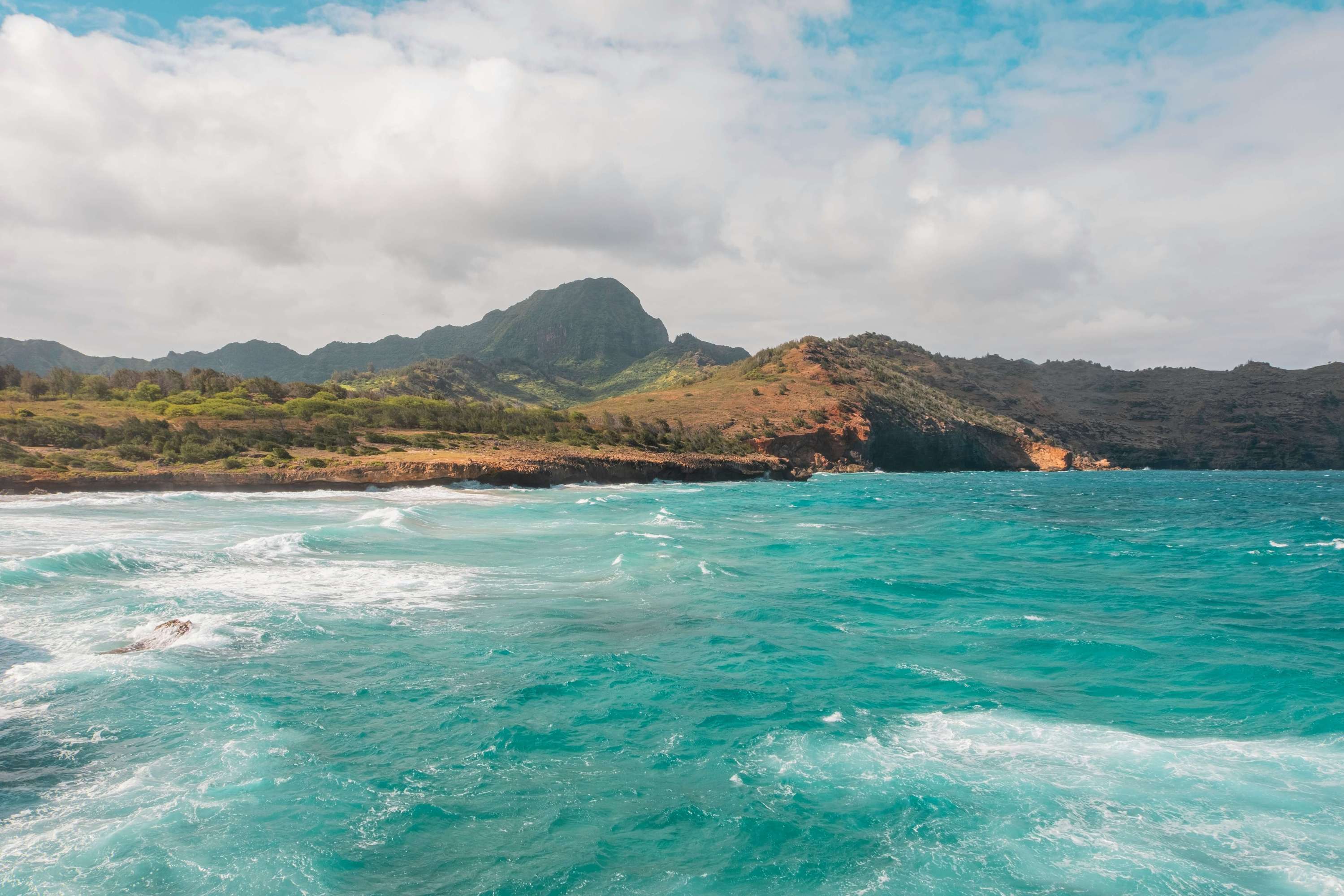a great photo of clear blue waters and waves off the coastline of kauaia