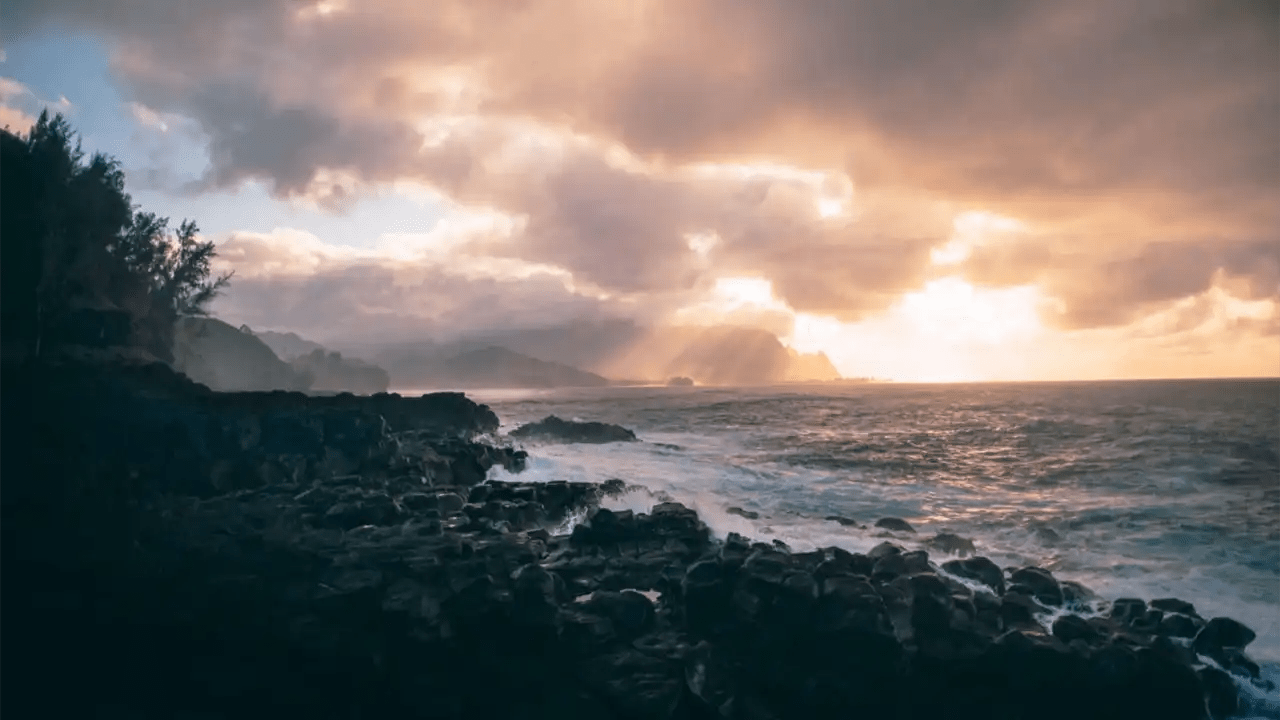 discover-what-you-need-to-know-about-hiking-hanakapiai-falls Rocky coastline at sunrise with dramatic clouds and waves crashing.